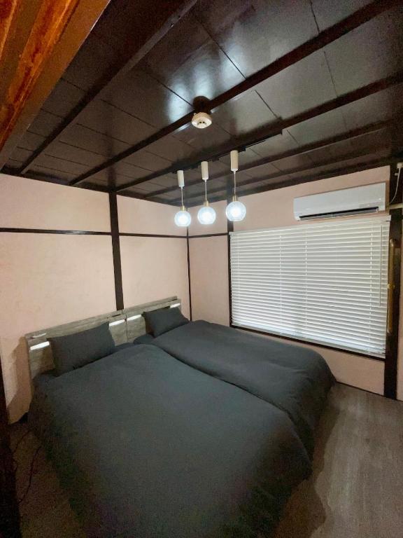 a bedroom with a large bed and a window at サニーサイドホステル2号館 in Uji