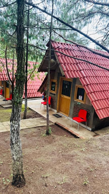 a house with a red roof and red chairs at Cabañas Recor in Tepoxcuautla