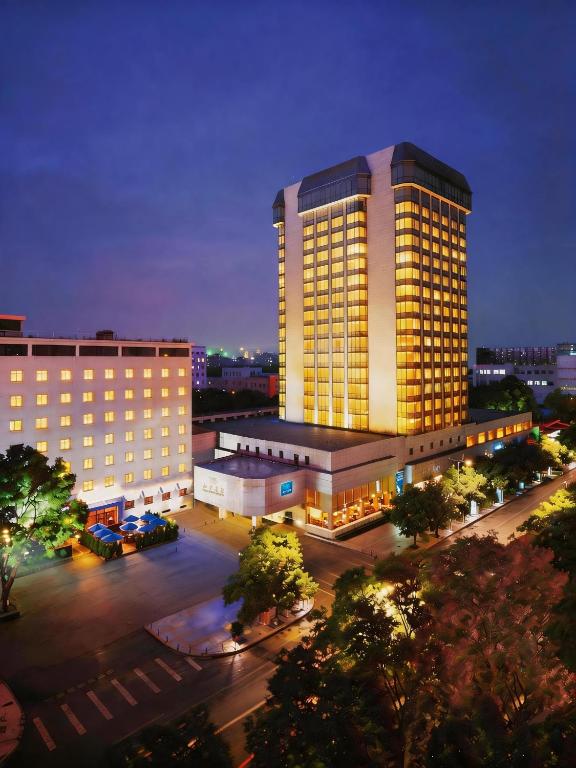 a lit up building with a parking lot in front of it at Peace Hotel Beijing in Beijing