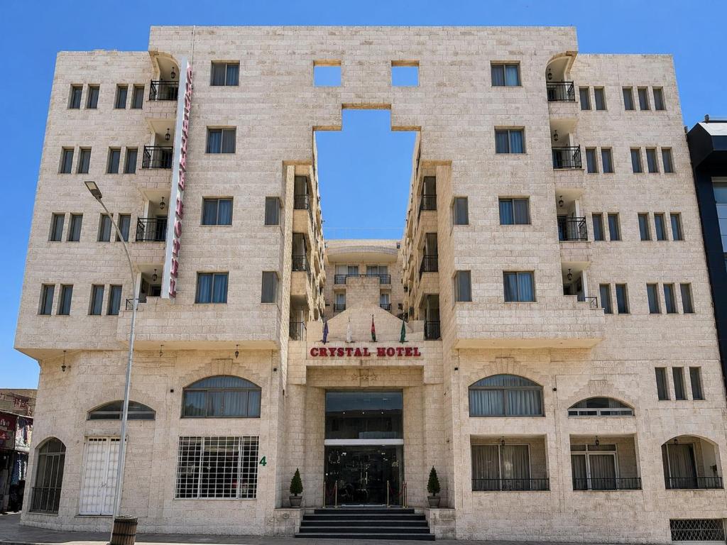 a large brick building with a sign on it at Crystal Hotel By FHM in Aqaba