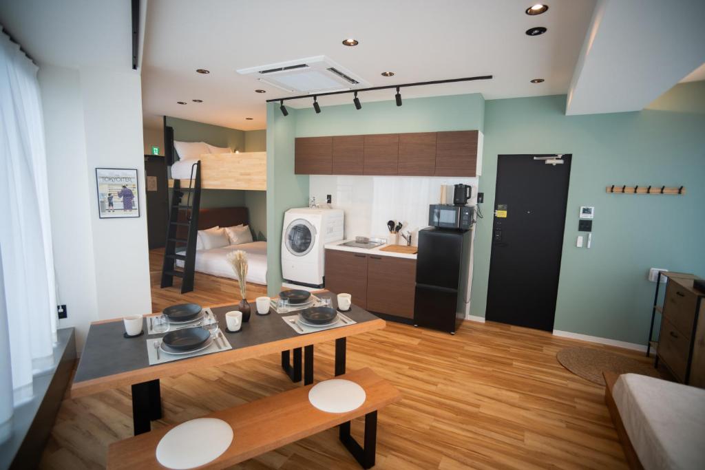 a kitchen and living room with a table and a refrigerator at ORI Ikebukuro in Tokyo