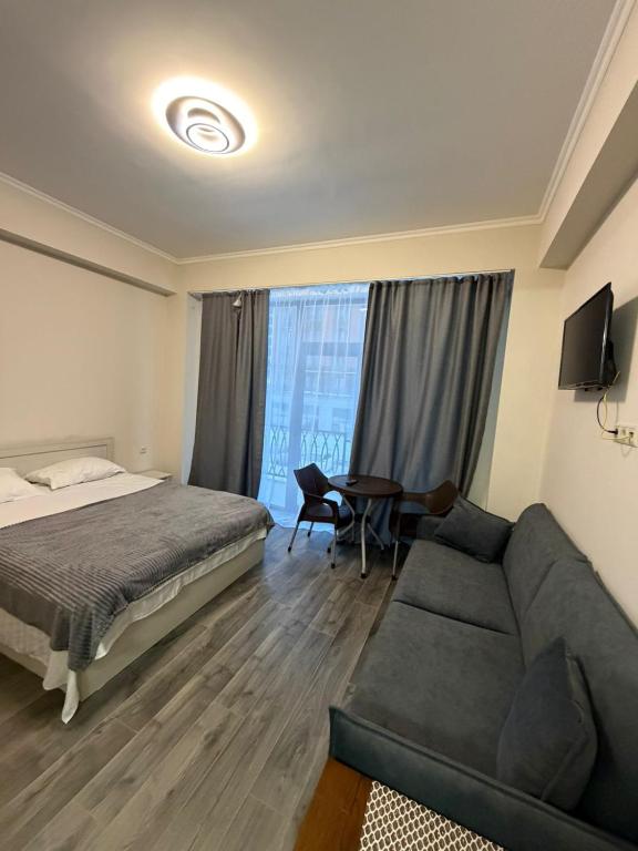 a bedroom with a bed and a couch and a table at Alvina complex in Tsaghkadzor