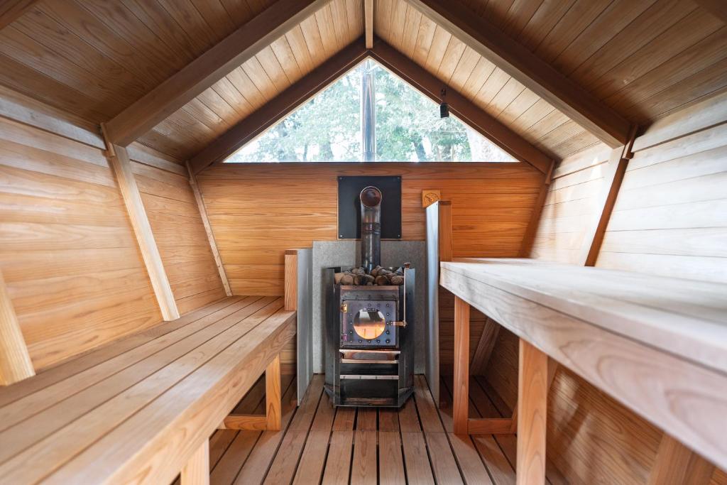 a wood stove in a sauna with a window at u10 -ユーテン- in Kakegawa