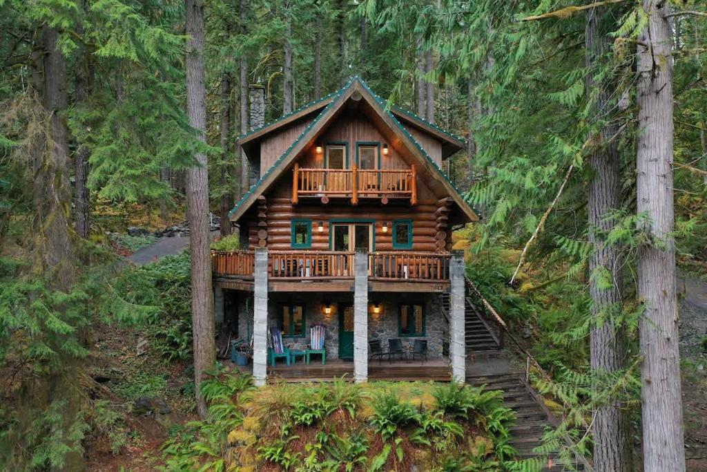 Eine Blockhütte im Wald mit Terrasse in der Unterkunft ArborMyst in Glacier