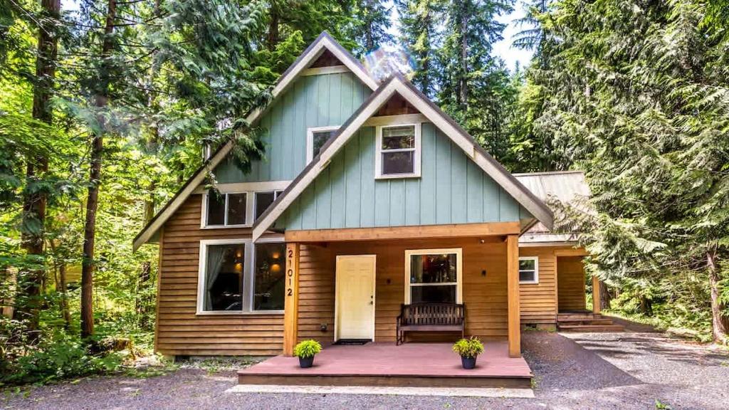 a tiny house in the woods with a porch at Heliotrope Haus in Glacier