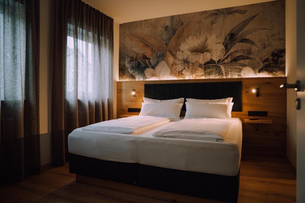 a bedroom with a bed with a painting on the wall at Appartementhaus Absmeier in Bad Füssing