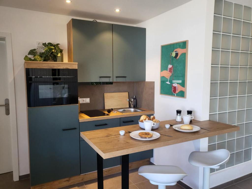 a kitchen with a wooden table and a blue refrigerator at Haus Eintracht Appartment 3 in Sankt Peter-Ording