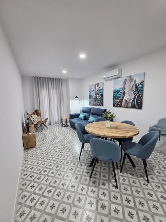 a living room with a table and blue chairs at LAS CASITAS DE JISA in Talavera de la Reina