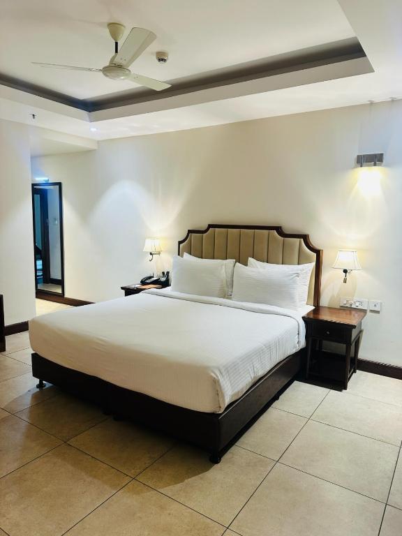 a bedroom with a large bed with white sheets and pillows at Park Selections in Bhubaneshwar