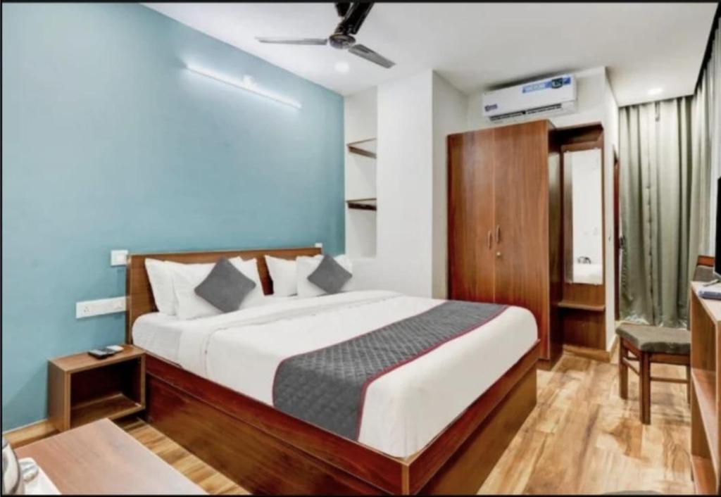a bedroom with a bed with a blue wall at RLV green palace in Bangalore