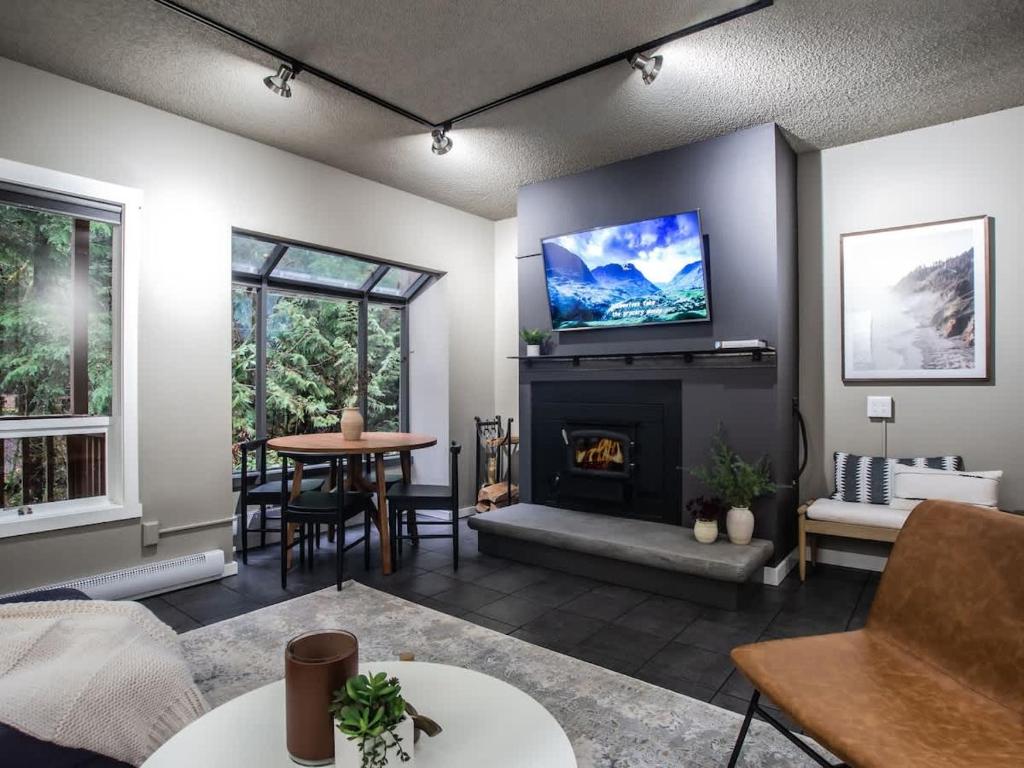 a living room with a fireplace and a flat screen tv at Snowater Respite in Glacier