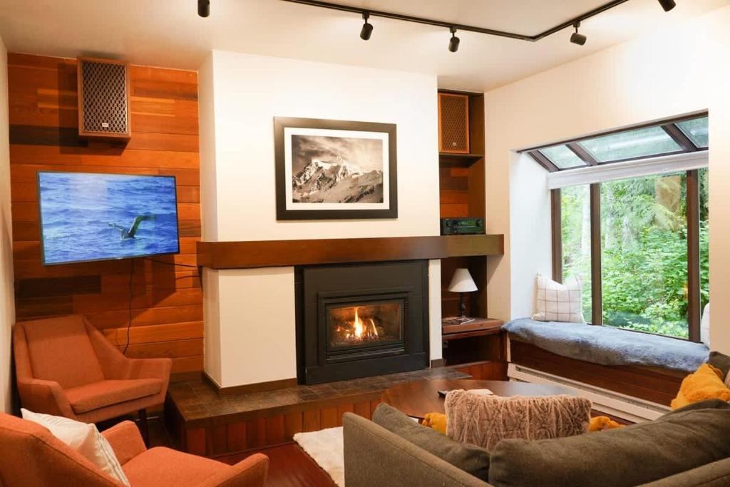 ein Wohnzimmer mit Kamin und Fernseher in der Unterkunft Summit Suite in Glacier