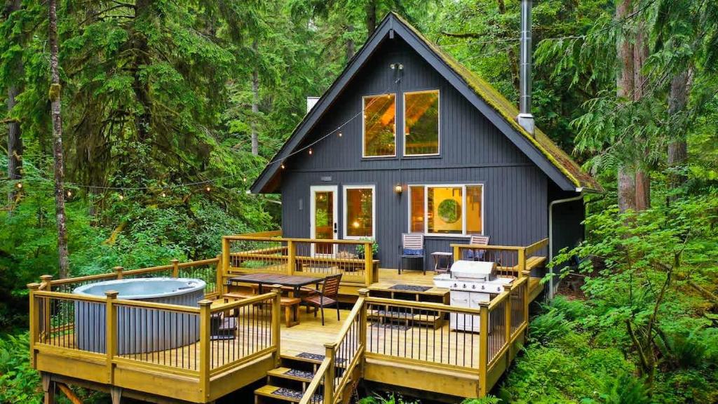 a tiny house in the woods with a deck at Sweet Seclusion in Glacier