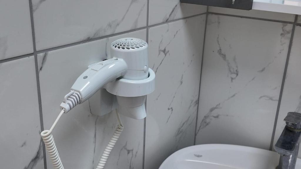 a bathroom with a blow dryer and a toilet at Arsuz Suite House in Arsuz