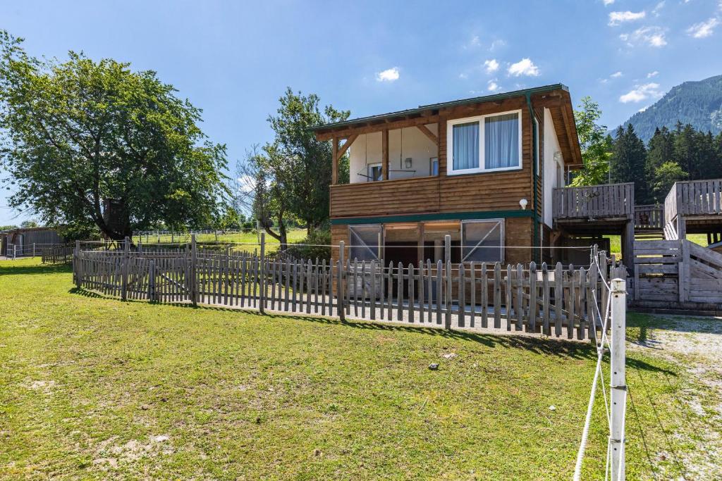 a house with a wooden fence in the yard at Pferdeblick Hütte auf der Rodeoranc in Rottenmann