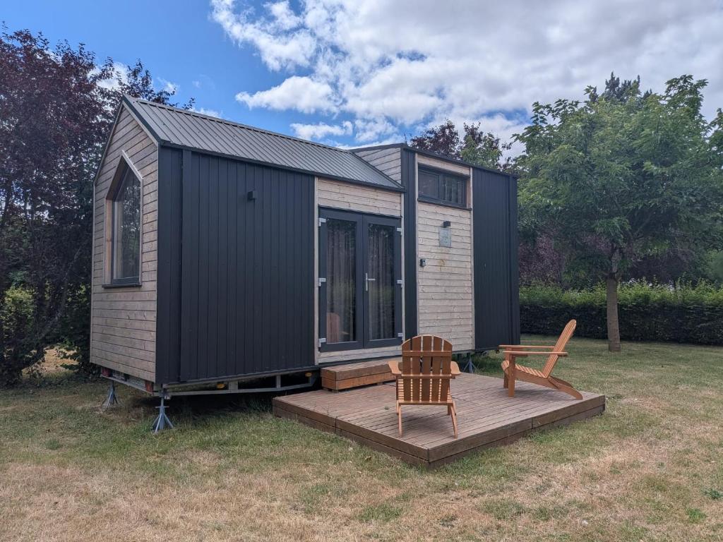 a tiny house with a deck and a bench at Rosemont Retreat by Tiny Away in Bessé-sur-Braye