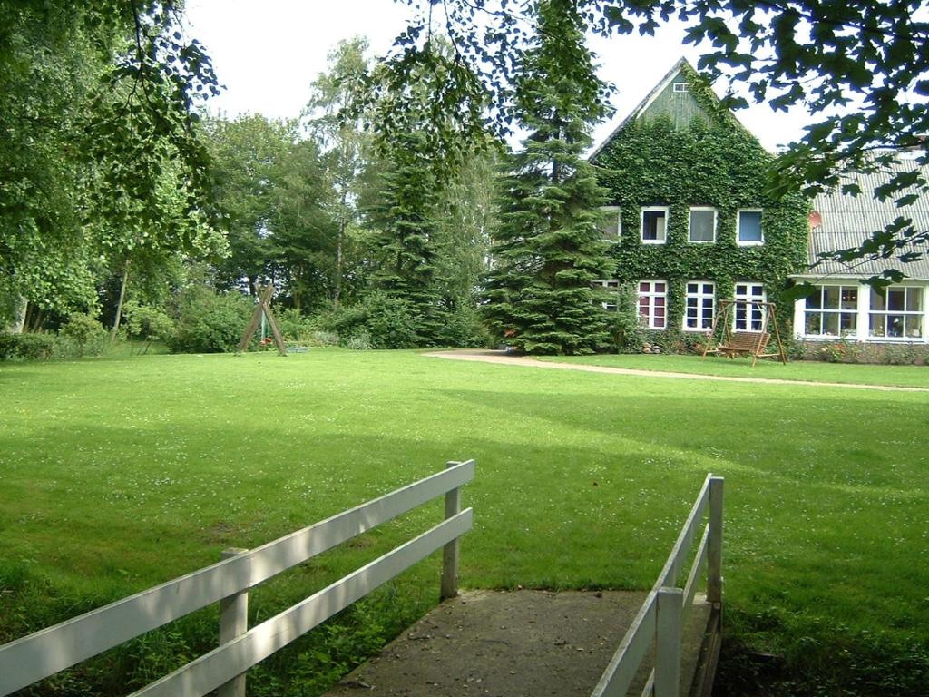 einen Zaun vor einem großen Hof mit einem Haus in der Unterkunft Erlebnishof Katthusen in Otterndorf