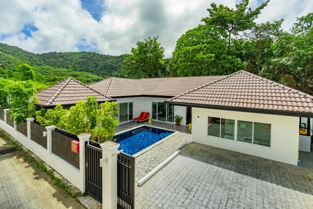 a villa with a swimming pool in front of a house at Chalong - 4 Bedroom Private Pool Villa - Phuket in Chalong