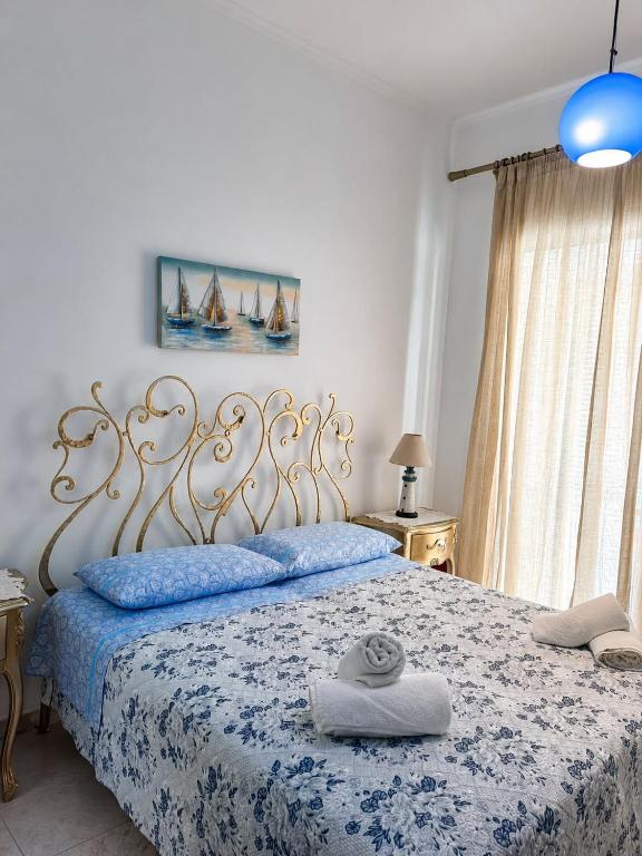 a bedroom with a bed with a blue and white blanket at Casa Simonetta il Roseto in Ponza