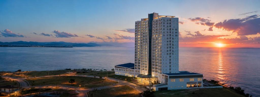 a tall building next to the water at sunset at Arterra Hotel and Resort in Mactan