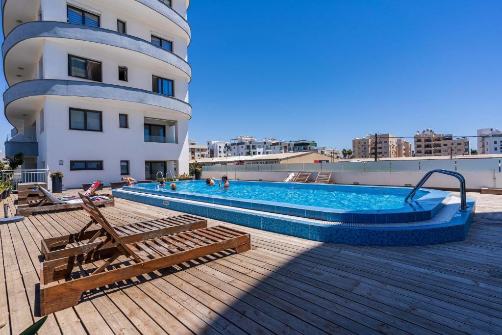 a swimming pool on the roof of a building at Bright Stylish Flat With Balcony & Shared Pool in Scala