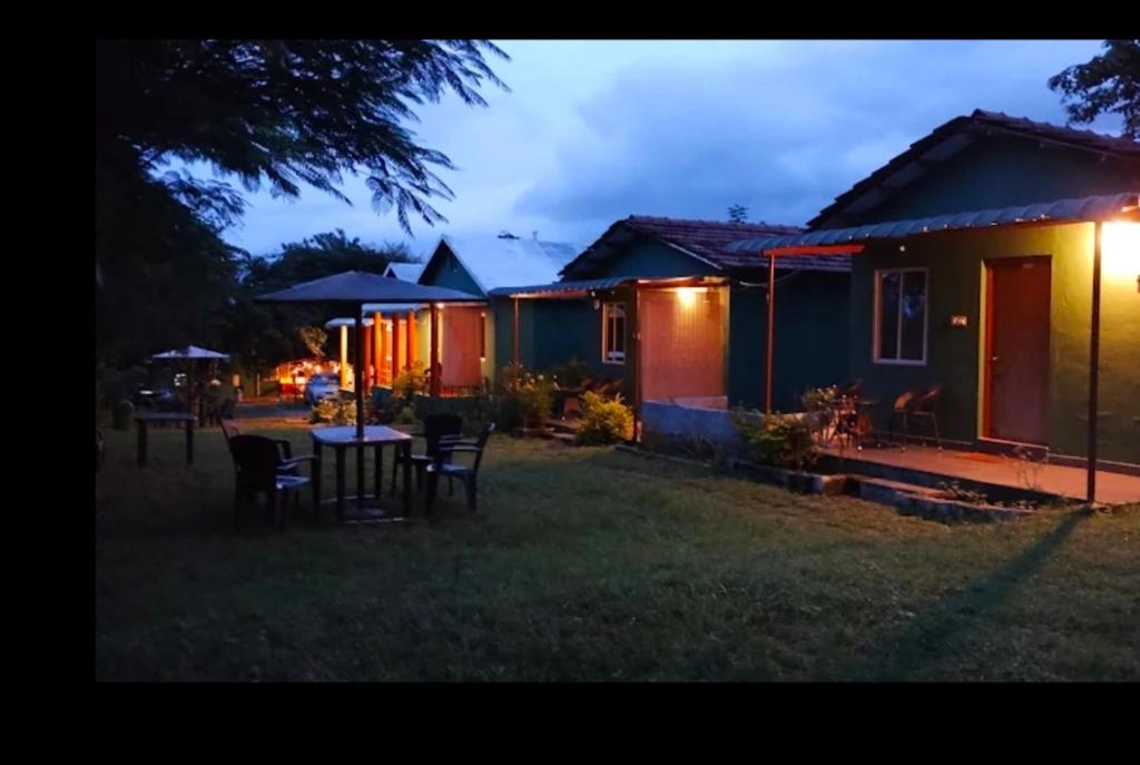 a group of houses in a yard at night at Wildfarms resort in Masinagudi