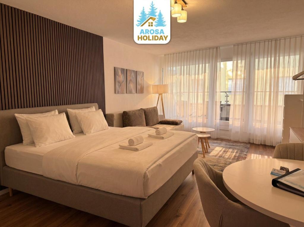 a bedroom with a large bed and a living room at Lorez 5A by Arosa Holiday in Arosa