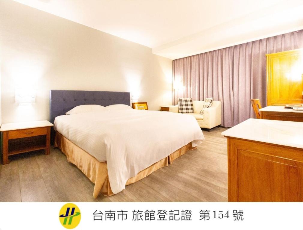 a hotel room with a large bed and a couch at Daniel Motel in Xinying