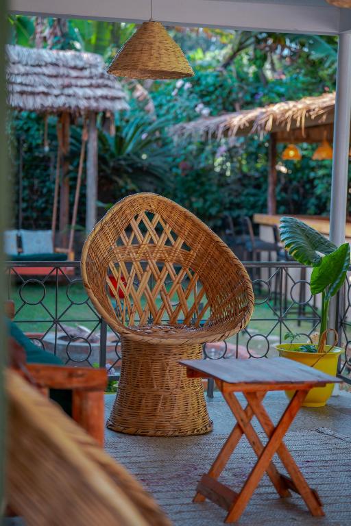 a wicker chair and a stool in a patio at Hakuna matata villas & hostels in Arusha