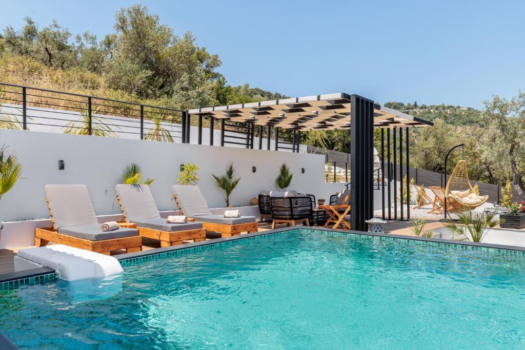 a swimming pool with chairs and a pergola at Villa Aegea in Skopelos Town