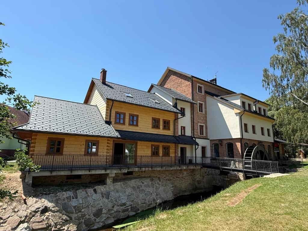 an old house on a bridge over a river at Feltlův mlýn v Borovnici in Borovnice