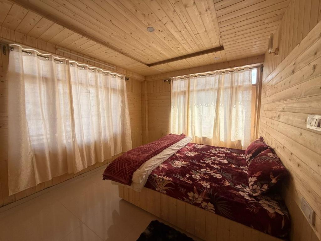 a bedroom with a bed in a wooden room at Himalyan Kitchen & Stay in Matiāna