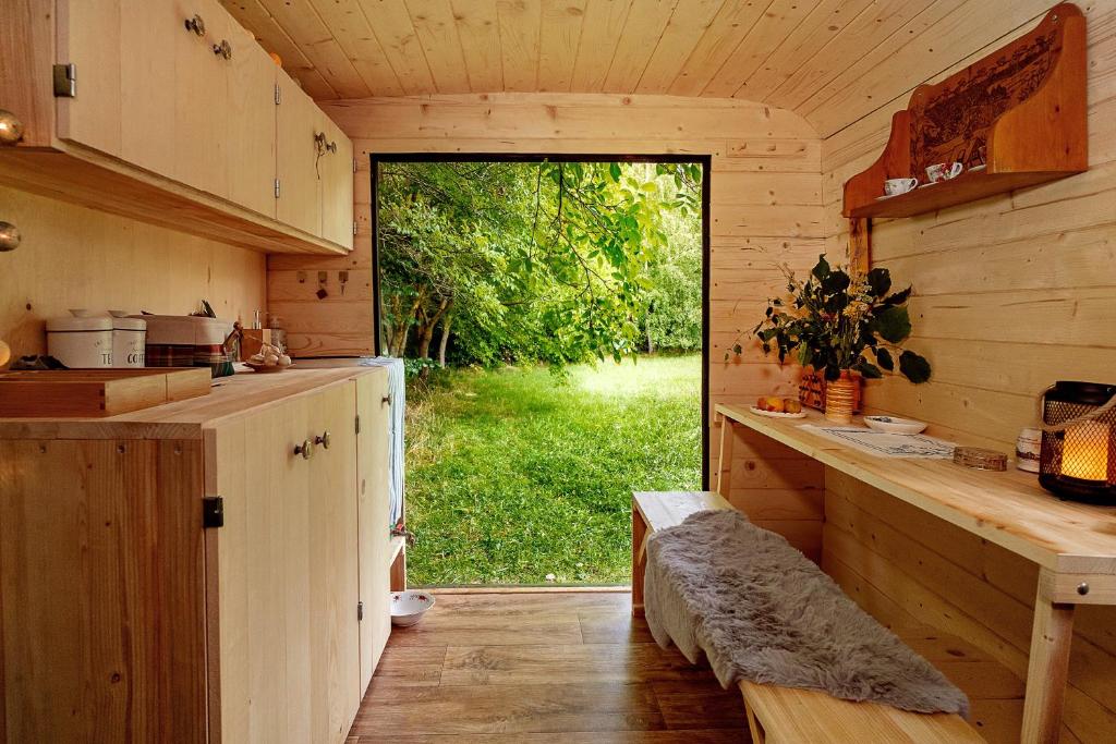 a kitchen with a large window in a log cabin at Maringotka Vojenského Stylu na Šumavě in Bošice