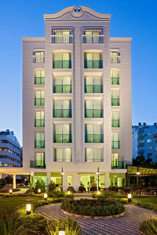 ein großes weißes Gebäude mit Lichtern davor in der Unterkunft The Room Hotel & Apartments in Antalya