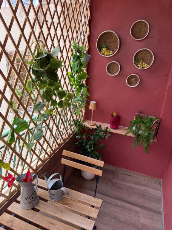 a room with a wooden bench and plants on a wall at Byout Beirut’s M1 in Beirut