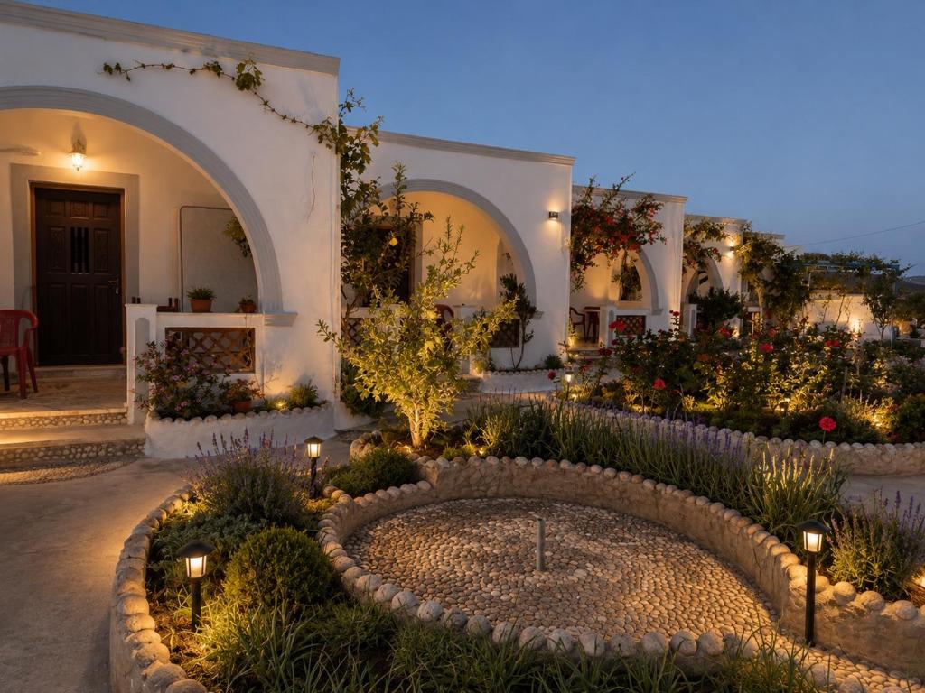 a courtyard of a house with a garden with a fountain at Mihalis Studios in Karpathos