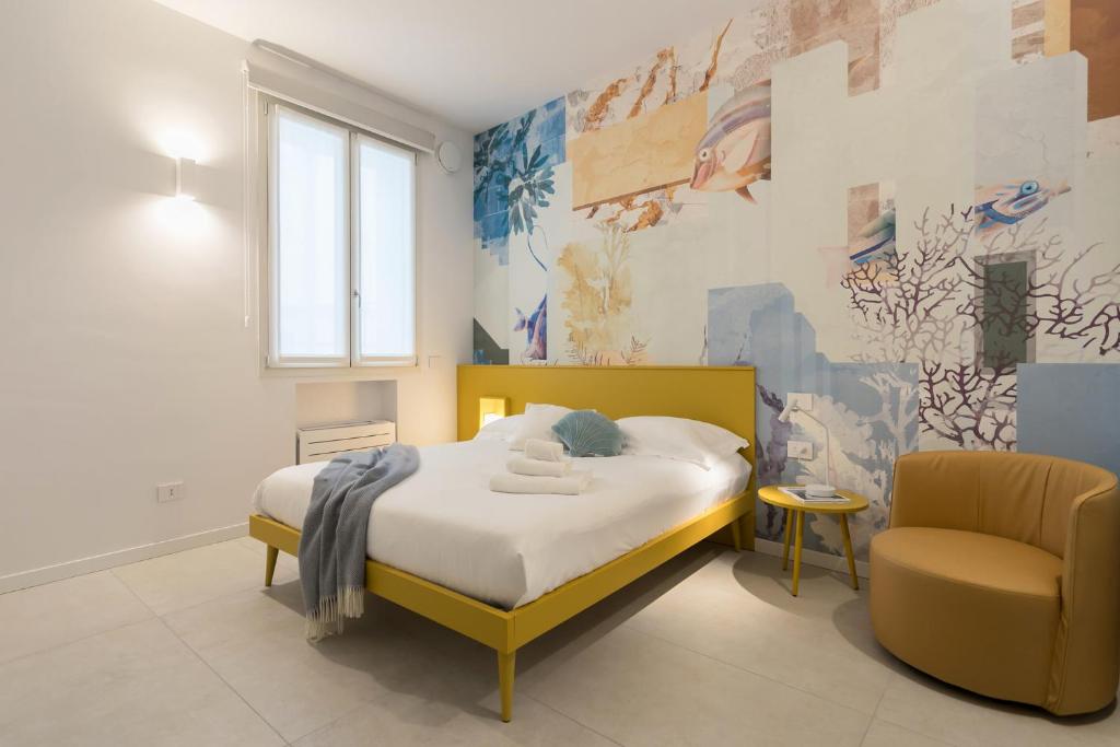 a bedroom with a yellow bed and a chair at GuestHost - Vivaldi Estate Apartment in Treviglio