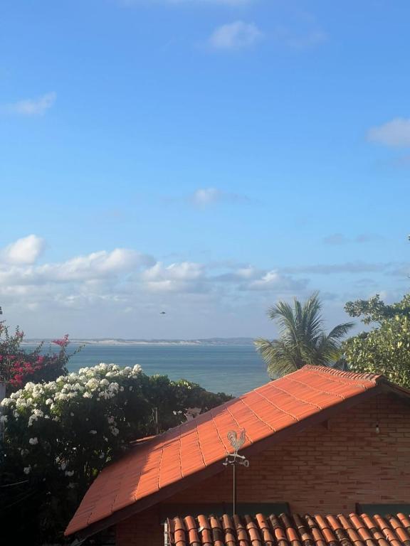 an orange roof of a building with the ocean in the background at Pipa Centro in Pipa