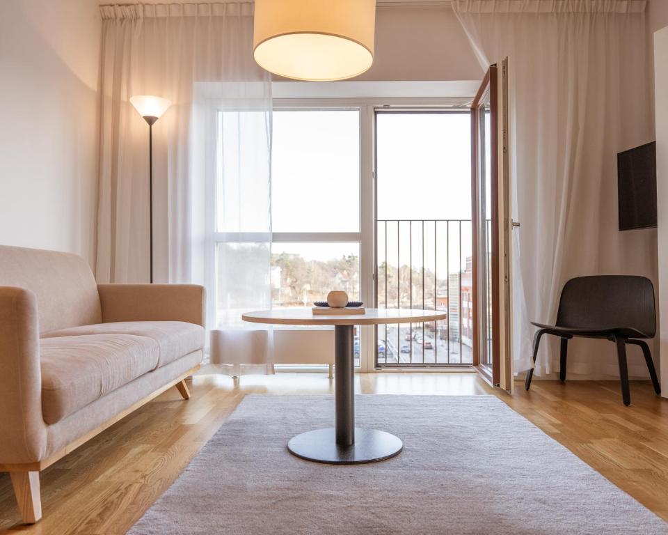 a living room with a couch and a table at Story Living Lidingö in Stockholm