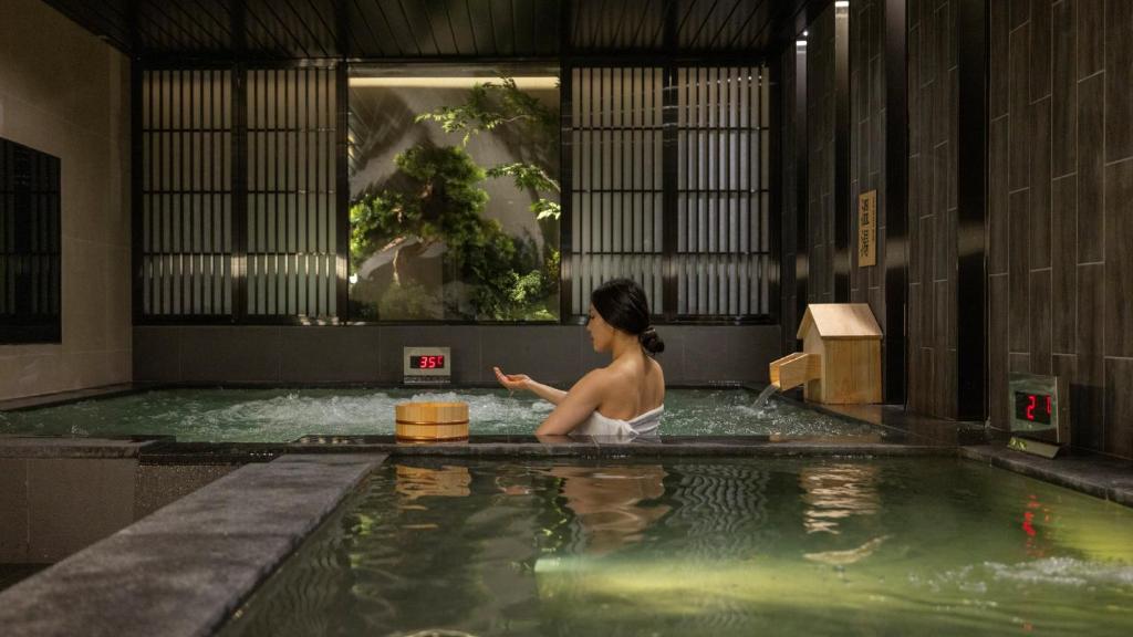 a woman in a jacuzzi in a swimming pool at Anook Hotel & Spa Bucheon Sangdong in Bucheon