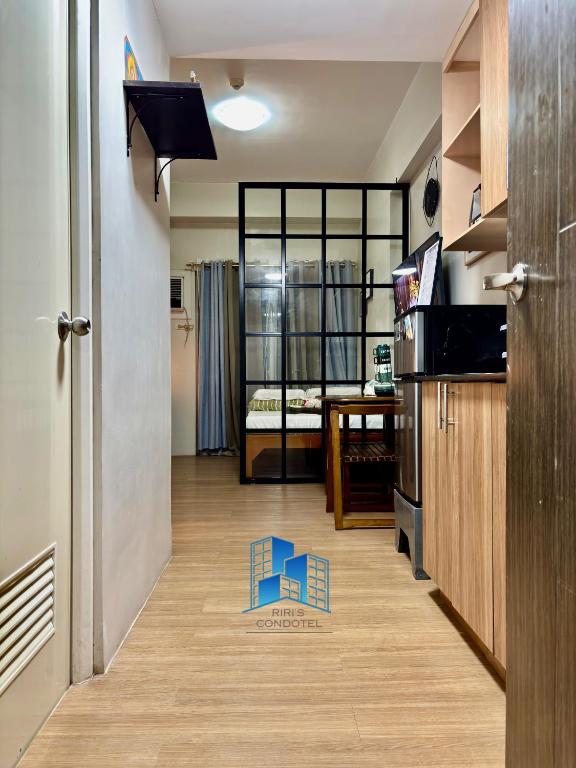 a room with a hallway with a kitchen and a door at Studio and 1 Bedroom Unit at Riri's Condotel, The Loop Tower in Cagayan de Oro
