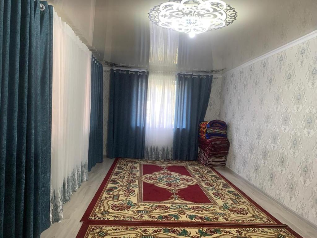 a room with a rug on the floor and a chandelier at Мой дом, жилье in Zarger