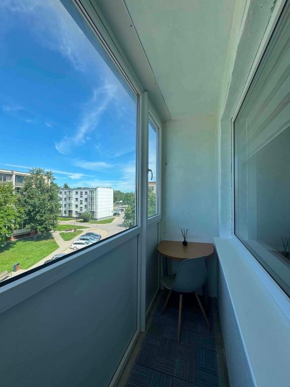 an empty room with a window and a table at Geri apartamentai in Naujoji Akmenė