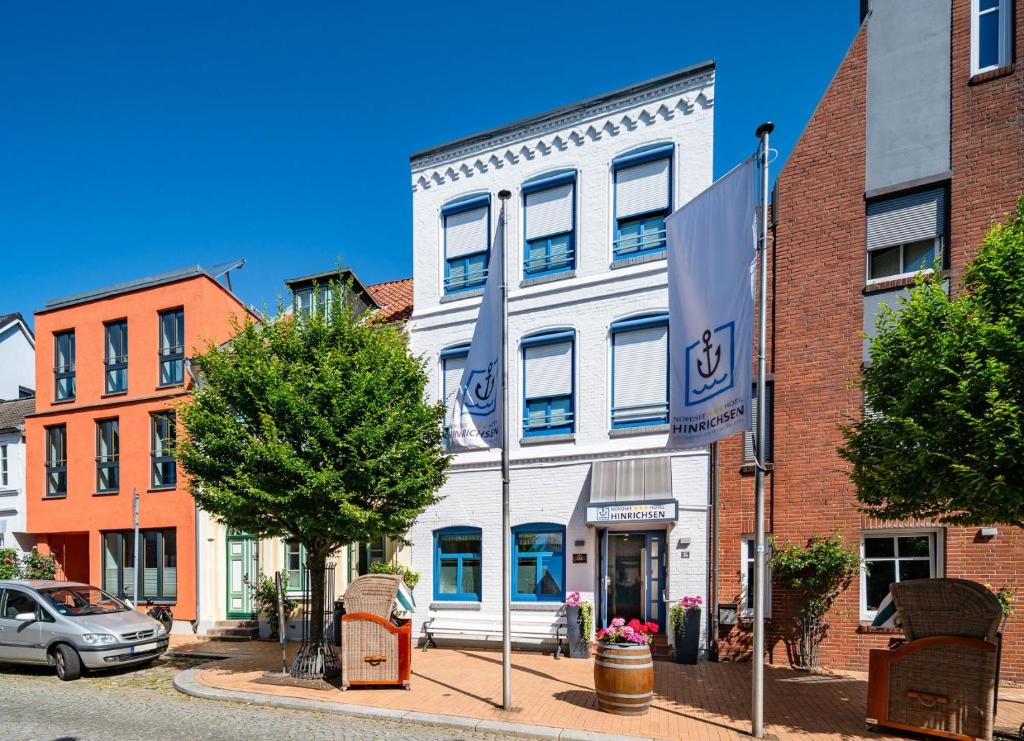 ein weißes Gebäude mit einer Flagge davor in der Unterkunft Nordsee-Hotel Hinrichsen in Husum