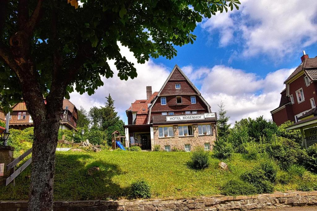 a large house sitting on top of a lush green field at Hotel Rosenhof - Braunlage in Braunlage