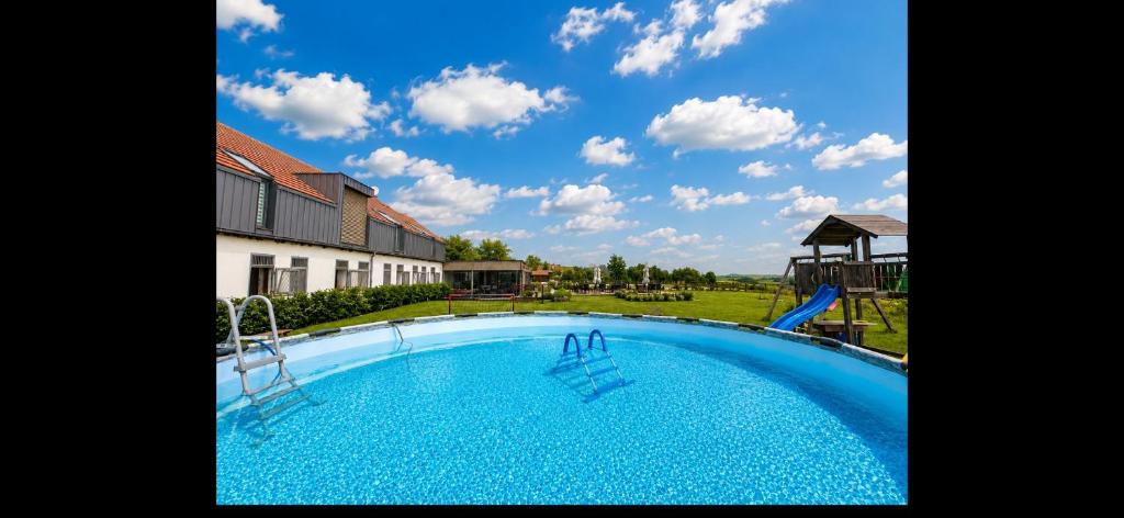 ein großes blaues Schwimmbecken mit Rutsche in der Unterkunft Bílichov in Bílichov