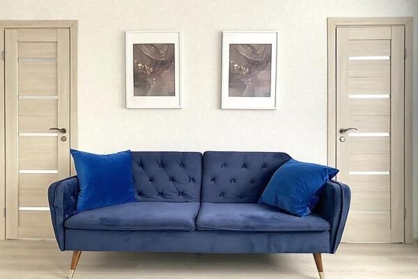 a blue couch in a living room with two doors at Boarder City Center Apartment, Võidu tn 5, Apt 16, 4th Floor, Narva in Narva