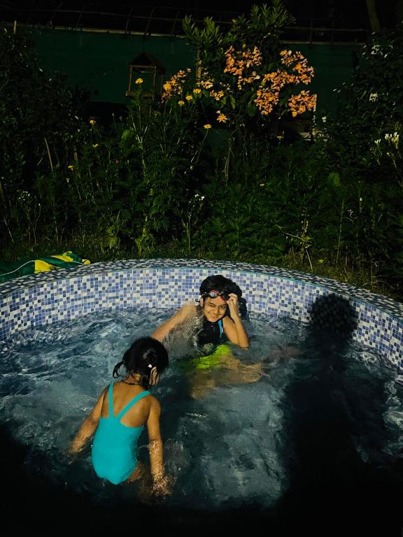a couple of people in a swimming pool at Org Retreat & Farmstay in Guwahati