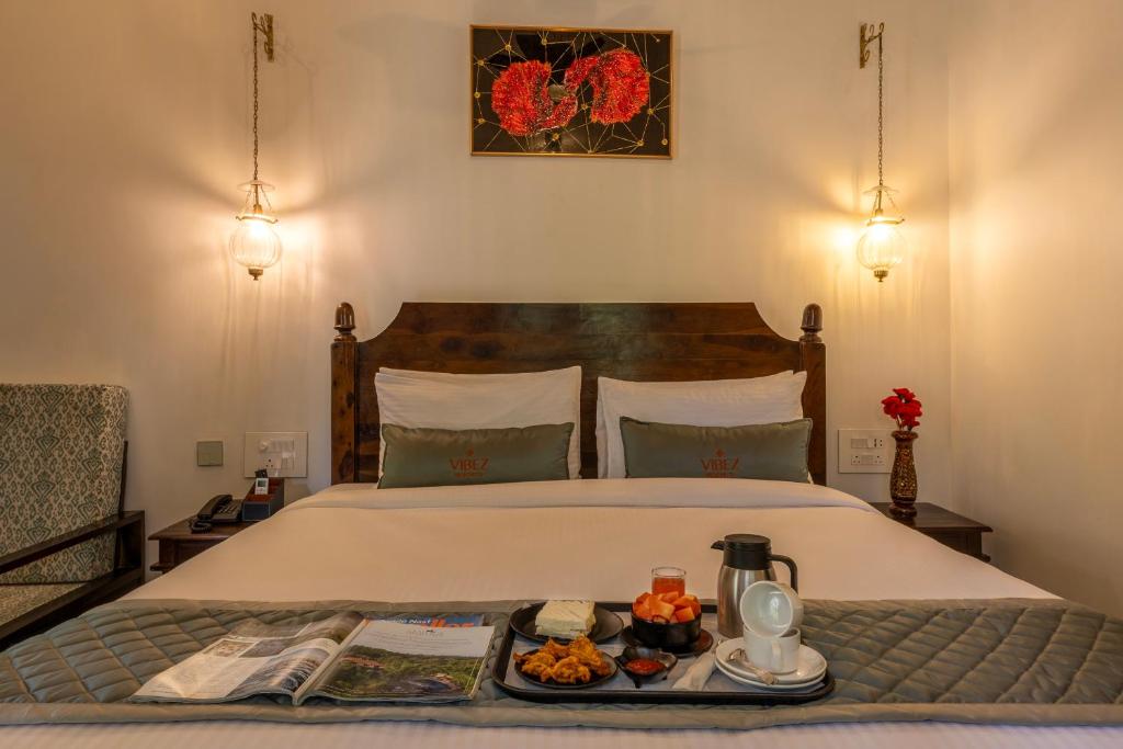 a bedroom with a bed with a tray of food on it at Ashvana Resort in Nidigere