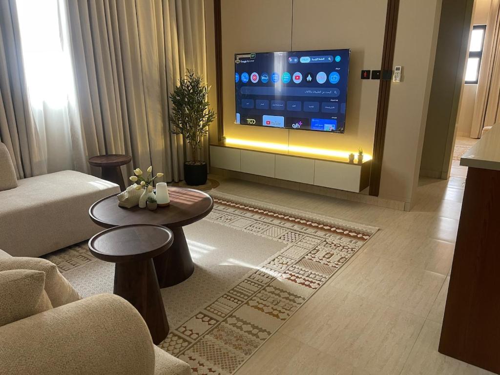 a living room with a couch and a tv at أواسِيس Oasis Stay in Al Muḩassin